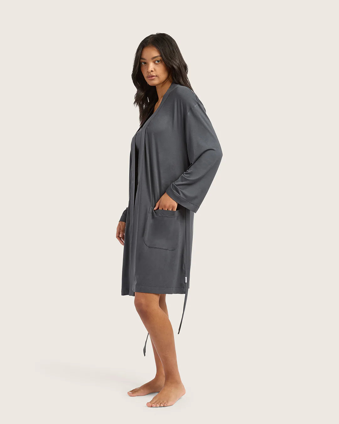Woman wearing a gray robe on a plain background