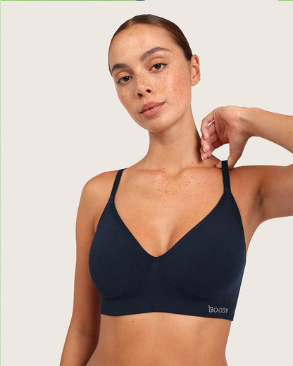 Woman wearing a navy blue bralette with 'Boody' branding on a light background