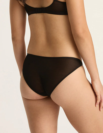 Person wearing black lingerie on a plain background