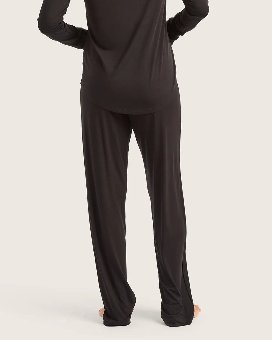 Person wearing a black loungewear set on a plain background