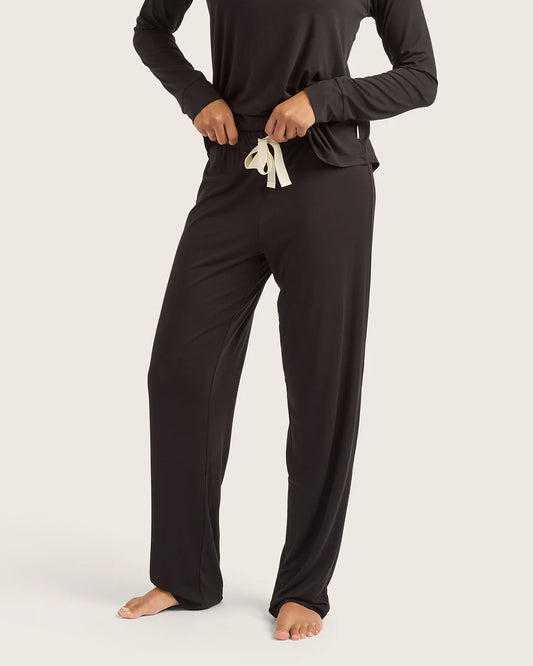 Person wearing black pajama set with white drawstring on a white background