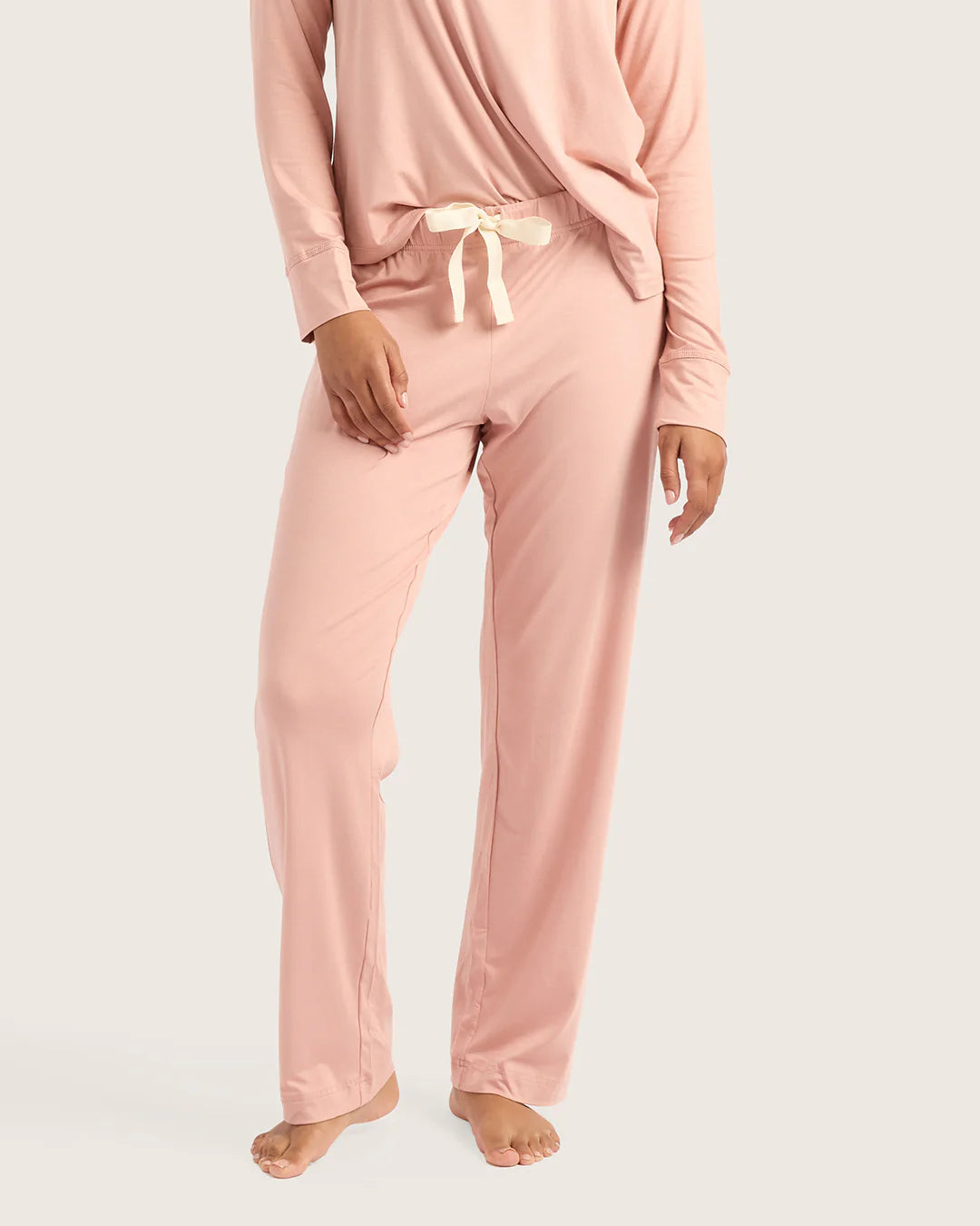 Person wearing a pink pajama set on a white background