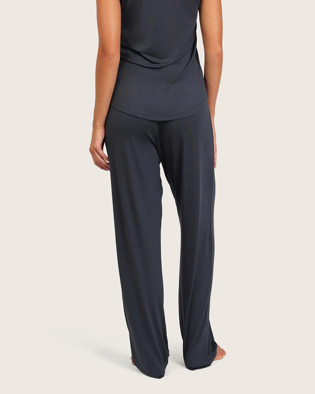 Person wearing a dark blue outfit on a light beige background