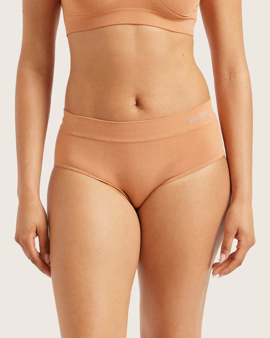 Person wearing a peach-colored sports bra and high-waisted underwear set on a light background