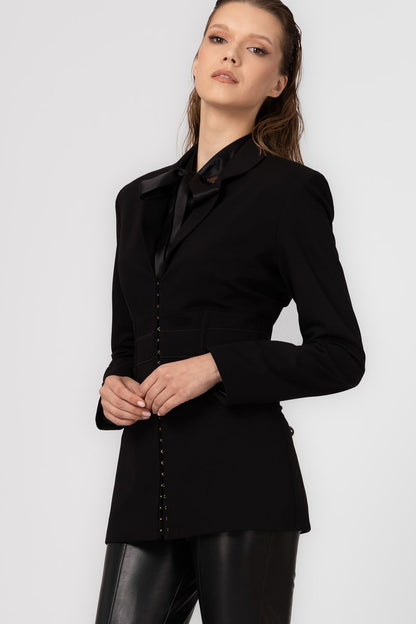 Woman wearing a black blazer against a white background